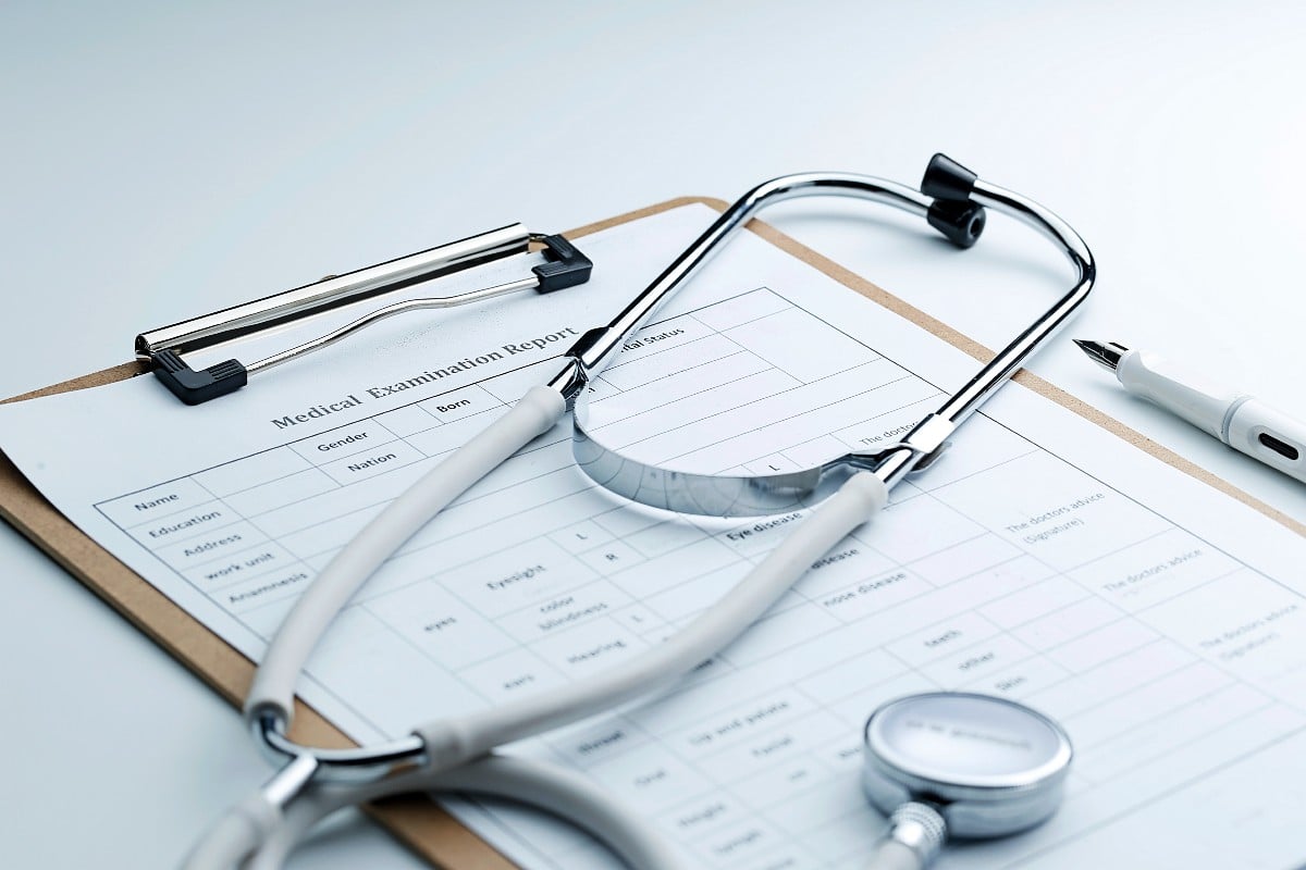 A medical examination report and a stethoscope on a desk